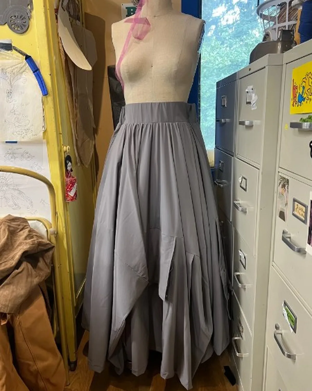 Gray pleated ensemble on a dress form in the Thornwear workroom