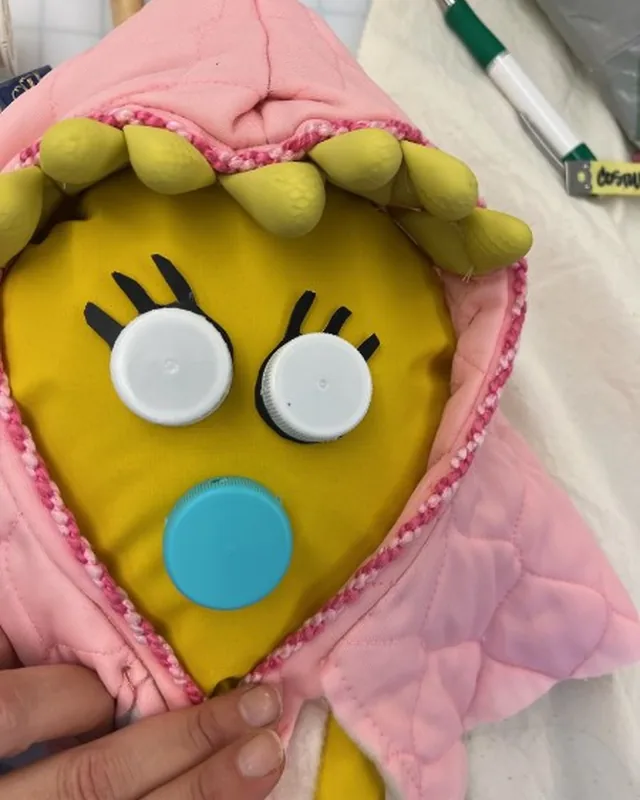 Soft-sculpture character face built from quilted fabric